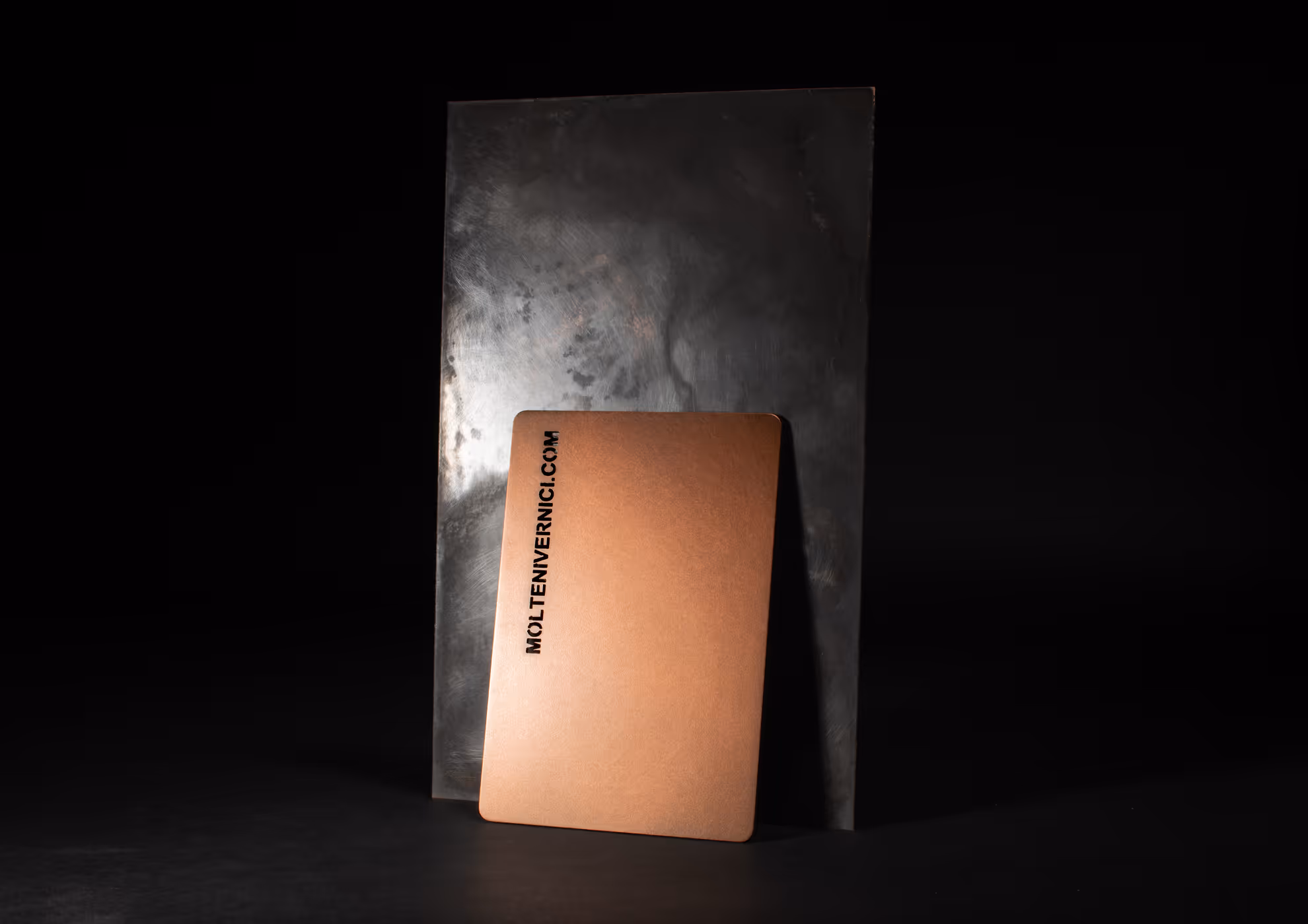 Tarjeta de MOLTENI-VERNICI con acabados metálicos sobre fondo oscuro
