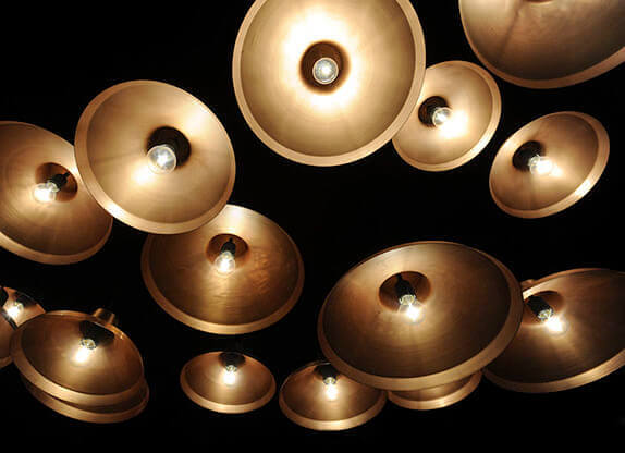 MOLTENI-VERNICI: Goldene Lampen leuchten kunstvoll auf schwarzem Hintergrund, Spezialfarben