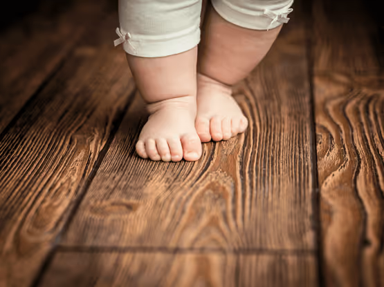 Piccoli piedi di bambino su un pavimento in legno verniciato da MOLTENI-VERNICI
