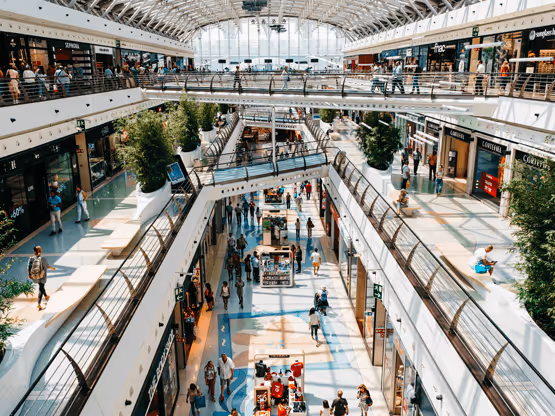 Centro commerciale moderno con negozi MOLTENI-VERNICI e persone che camminano