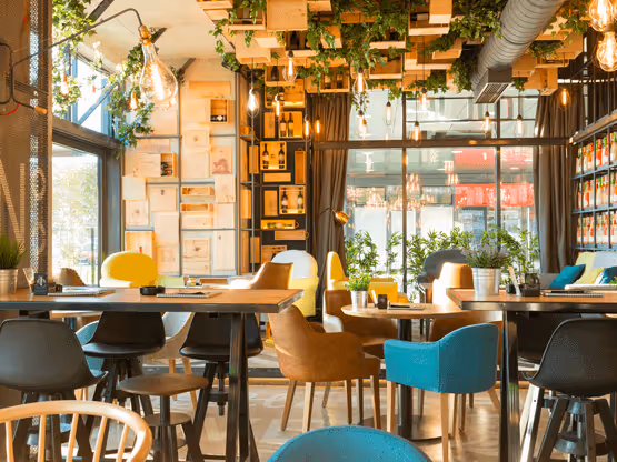 Interno di caffè moderno con vernice MOLTENI-VERNICI, sedie colorate e piante sospese