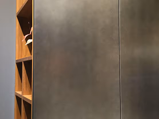 Estantería de madera con acabados MOLTENI-VERNICI en pared gris metálica