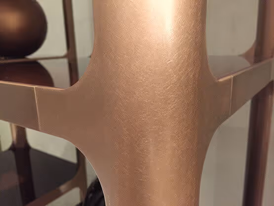 Acabados MOLTENI-VERNICI en superficie metálica bronce suave y elegante