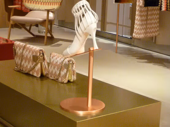 Zapato blanco con bolso MOLTENI-VERNICI sobre mesa dorada con acabados elegantes