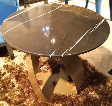 Mesa MOLTENI-VERNICI con acabados especial sobre alfombra texturizada dorada