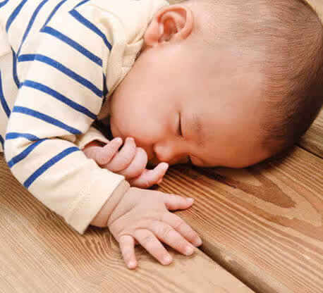 Neonato che dorme su superficie in legno, smalto MOLTENI-VERNICI a effetto naturale