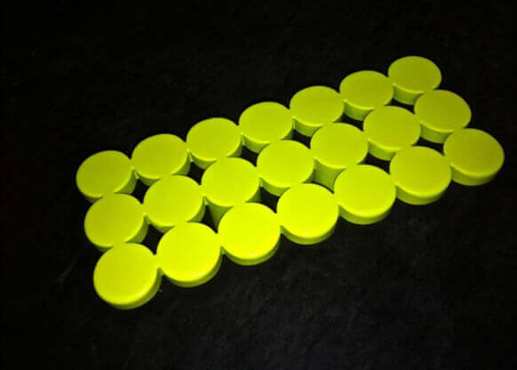 MOLTENI-VERNICI fluo paint bright yellow circular discs on dark background
