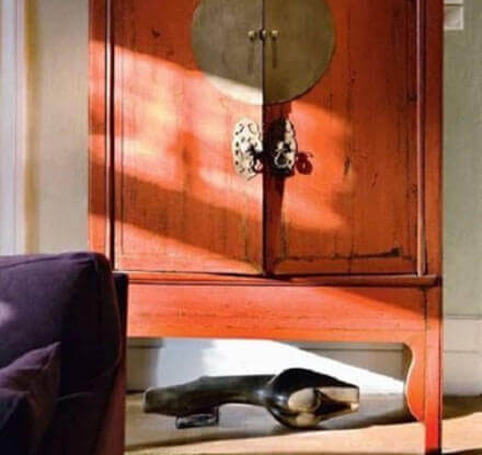 MOLTENI-VERNICI Speziallacke: Orangefarbener Schrank mit Sonnenlicht und dunkler Dekoration
