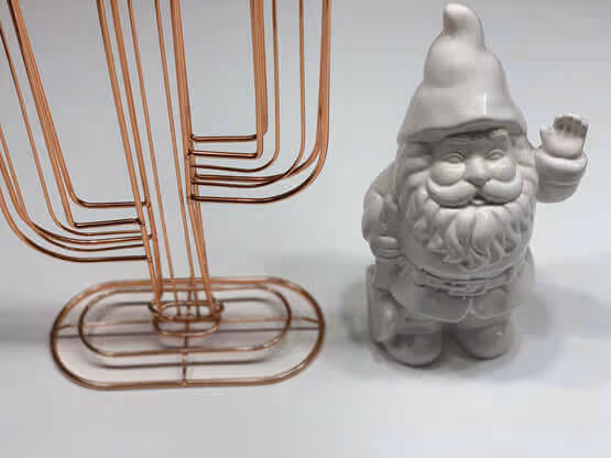 Gnomo in ceramica grigia con effetto materico MOLTENI-VERNICI accanto a struttura metallica