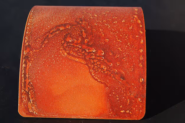 Acabados especial MOLTENI-VERNICI: superficie roja texturizada con gotas de agua