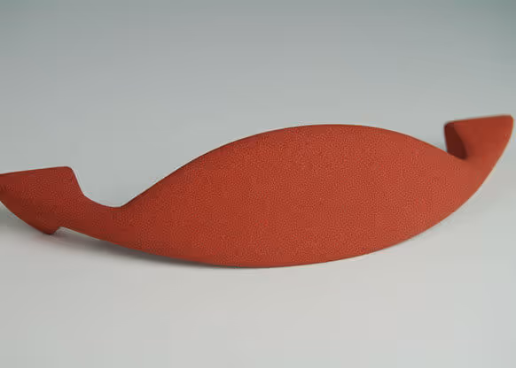 Objet courbe rouge mat, finition Molteni-Vernici, design minimaliste élégant