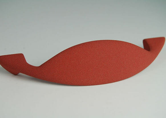 Objet courbe rouge mat, finition Molteni-Vernici, design minimaliste élégant