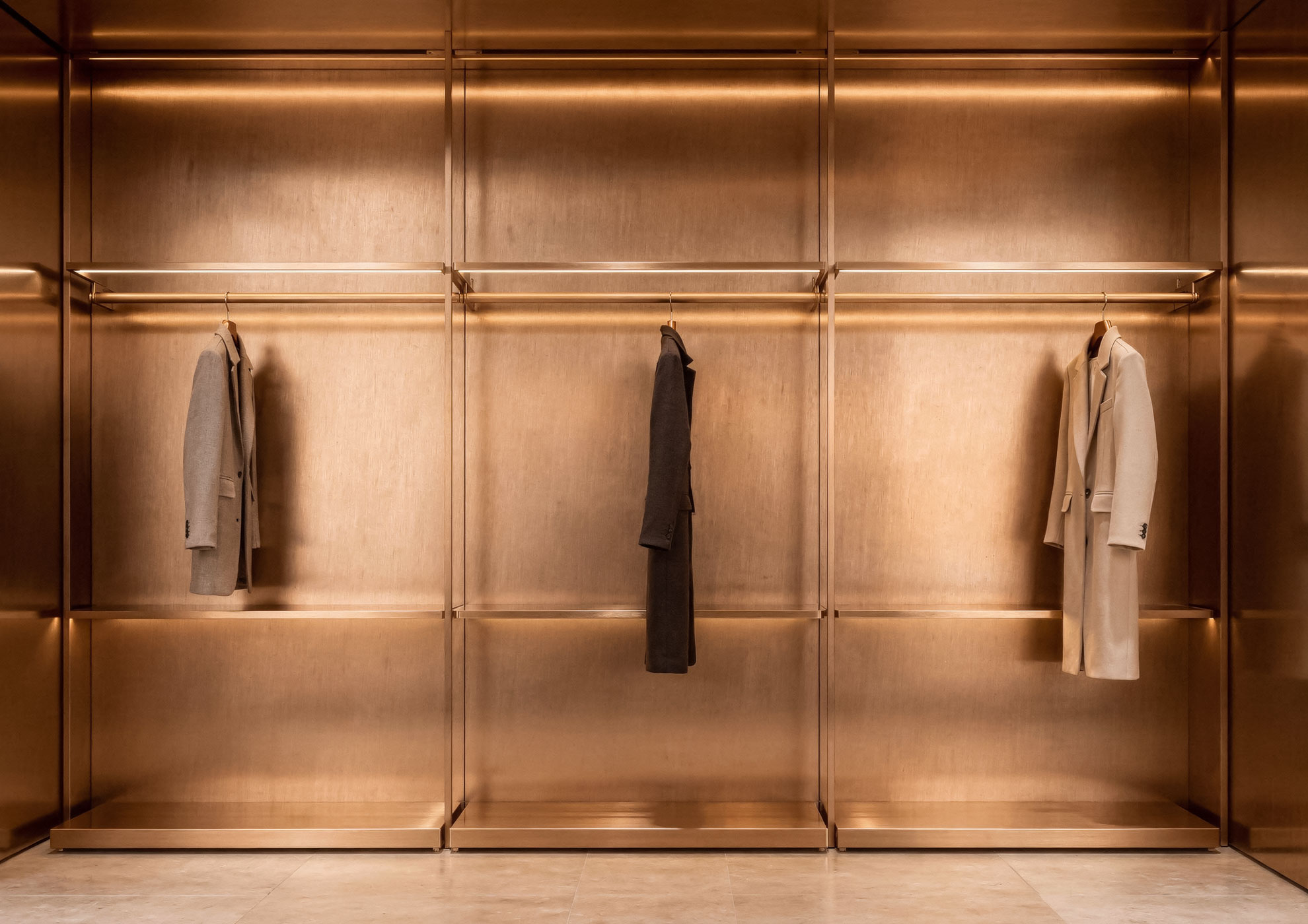 Luxury walk-in closet with walls finished in Rame Spazzolato Never Brushed by Molteni Vernici, a decorative metallic surface that enhances contemporary interior design elegance through a satinized copper effect.