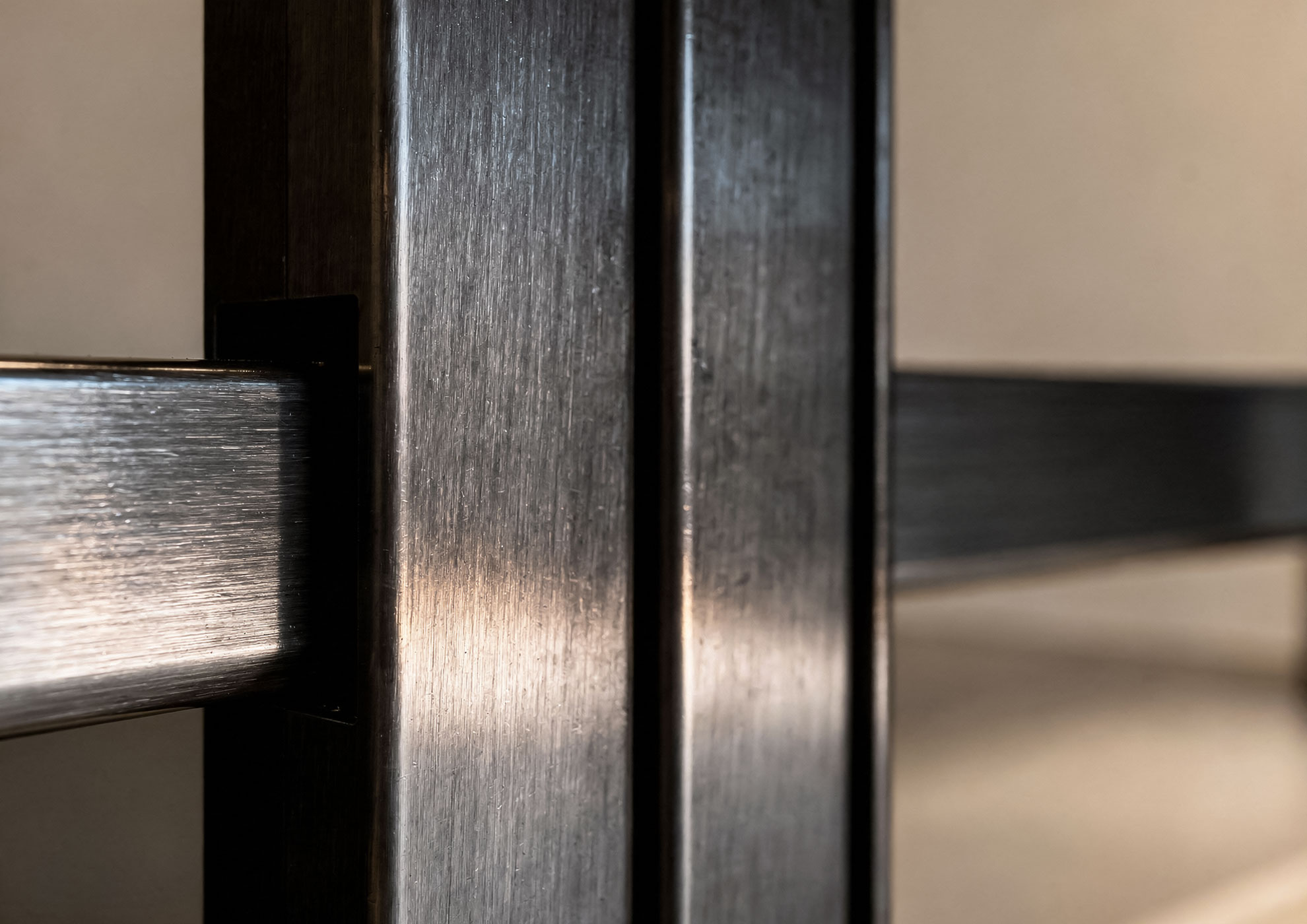 Structural frame in brushed metal with Never Brushed Molteni Vernici finish, close-up detail that reveals the premium texture and material character of the decorative surface for luxury interior design.