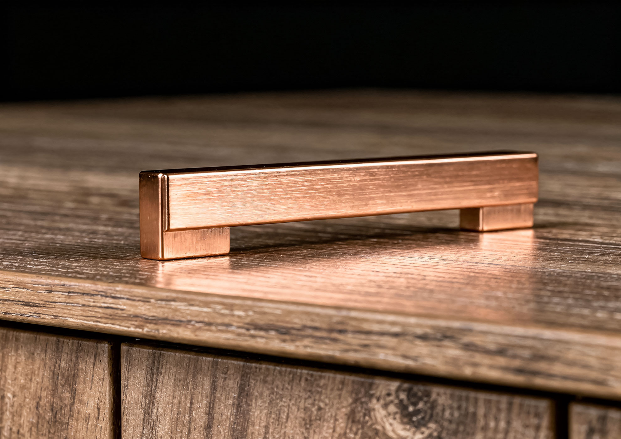 Minimal brushed copper handle with Never Brushed finish by Molteni Vernici, luxury metallic detail on dark wood furniture, premium decorative surface for contemporary interior design.