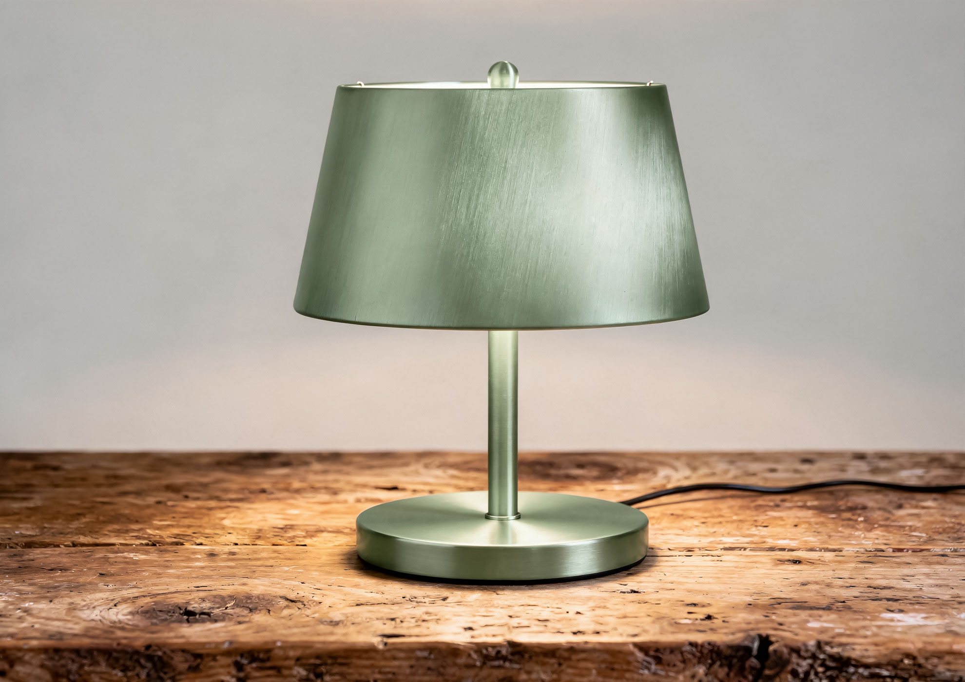 Designer table lamp with base and stem in green brushed metal, finished with Never Brushed metal-effect varnish Molteni Vernici, for luxury lighting with contemporary and sophisticated aesthetics.