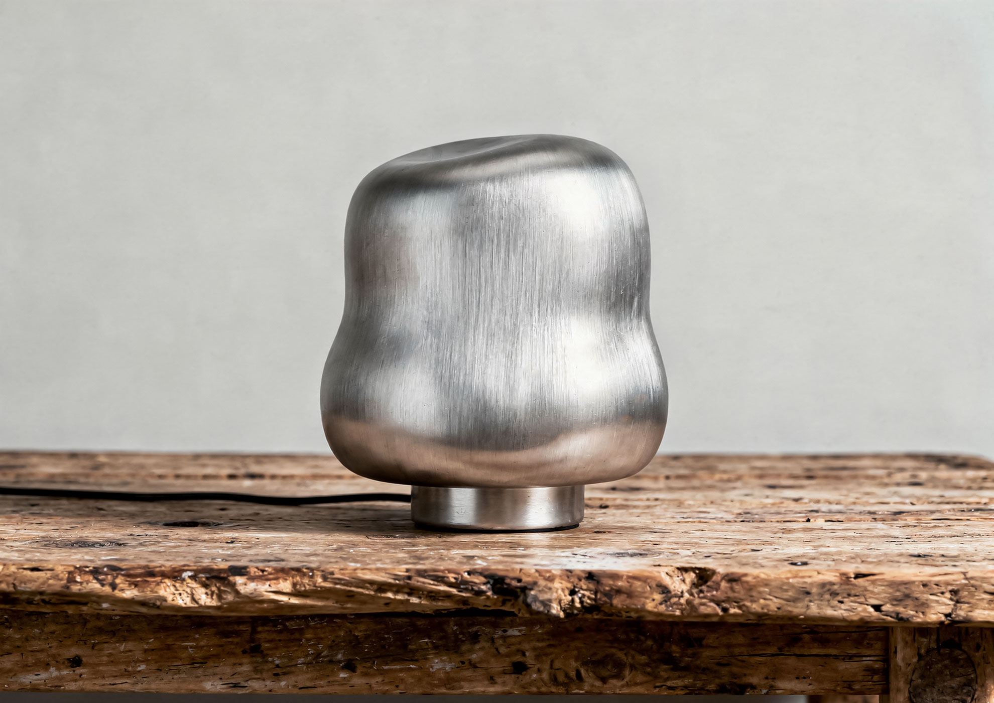 Minimalist metal sculpture with Never Brushed brushed silver finish by Molteni Vernici, premium decorative surface that enhances the materiality of contemporary design on wooden base.