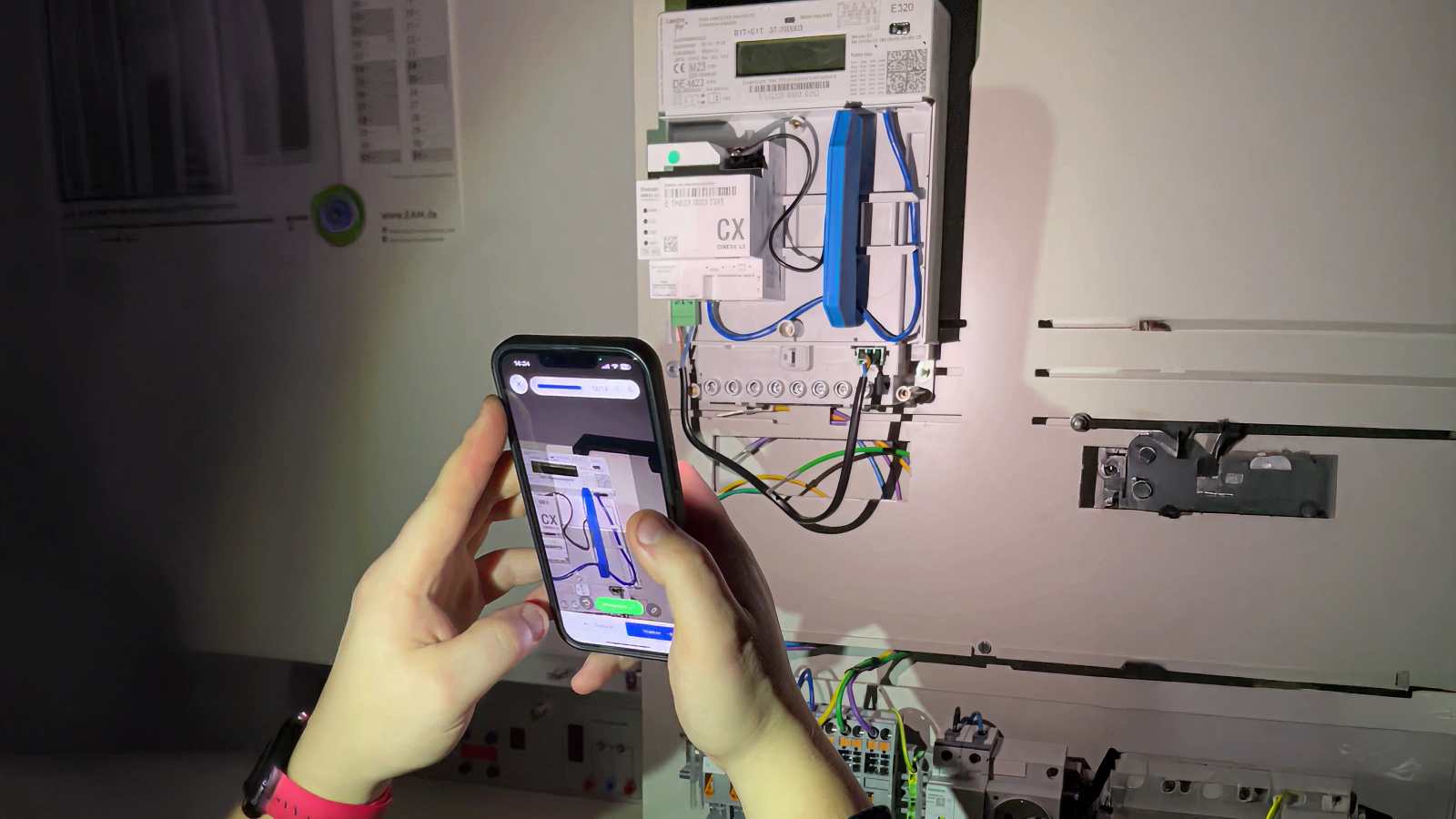 Technician from EAM performing an AI step verification on a smart meter cabling.