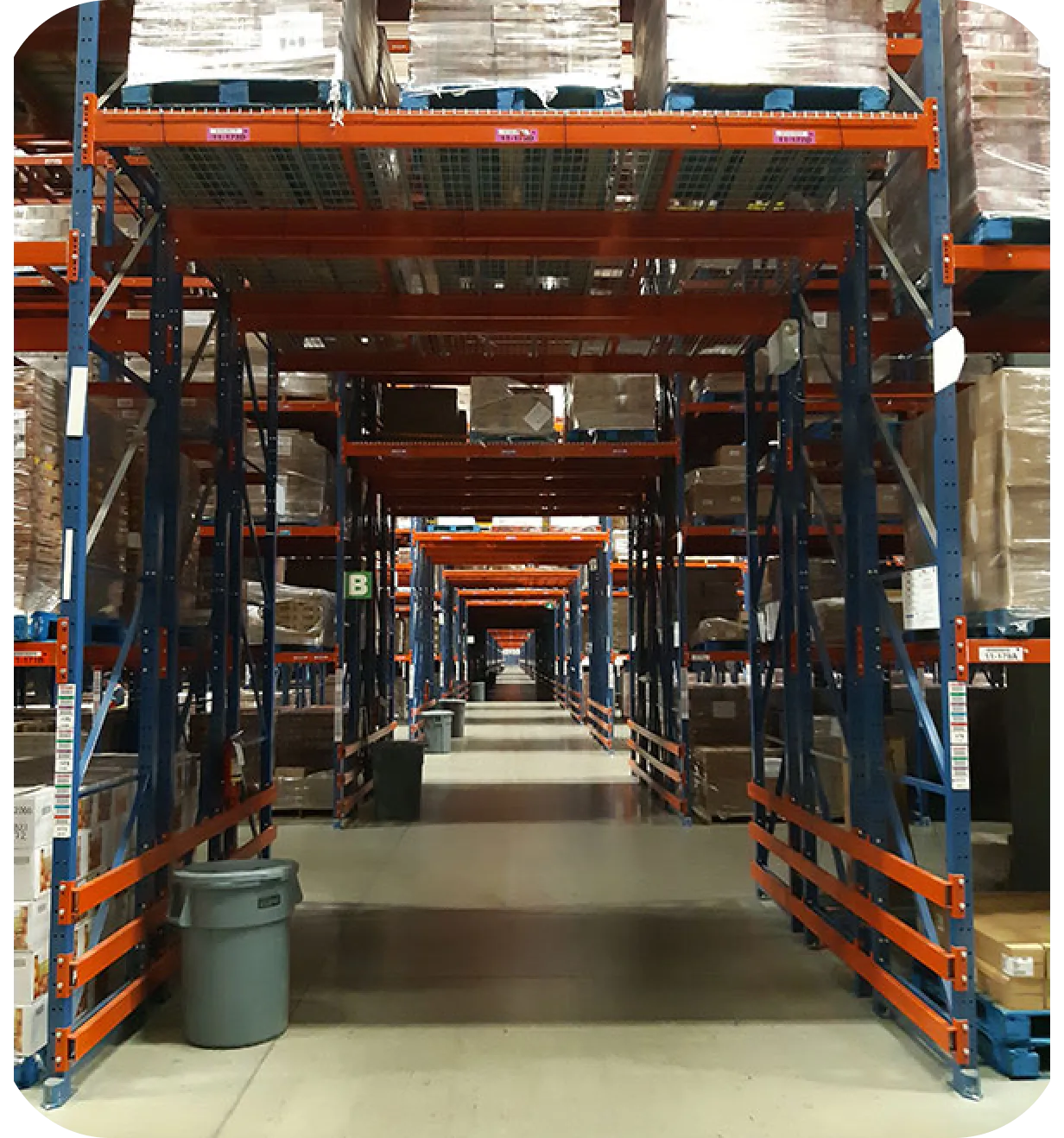 Warehouse aisle lined with pallet racking and stacked shipping boxes.