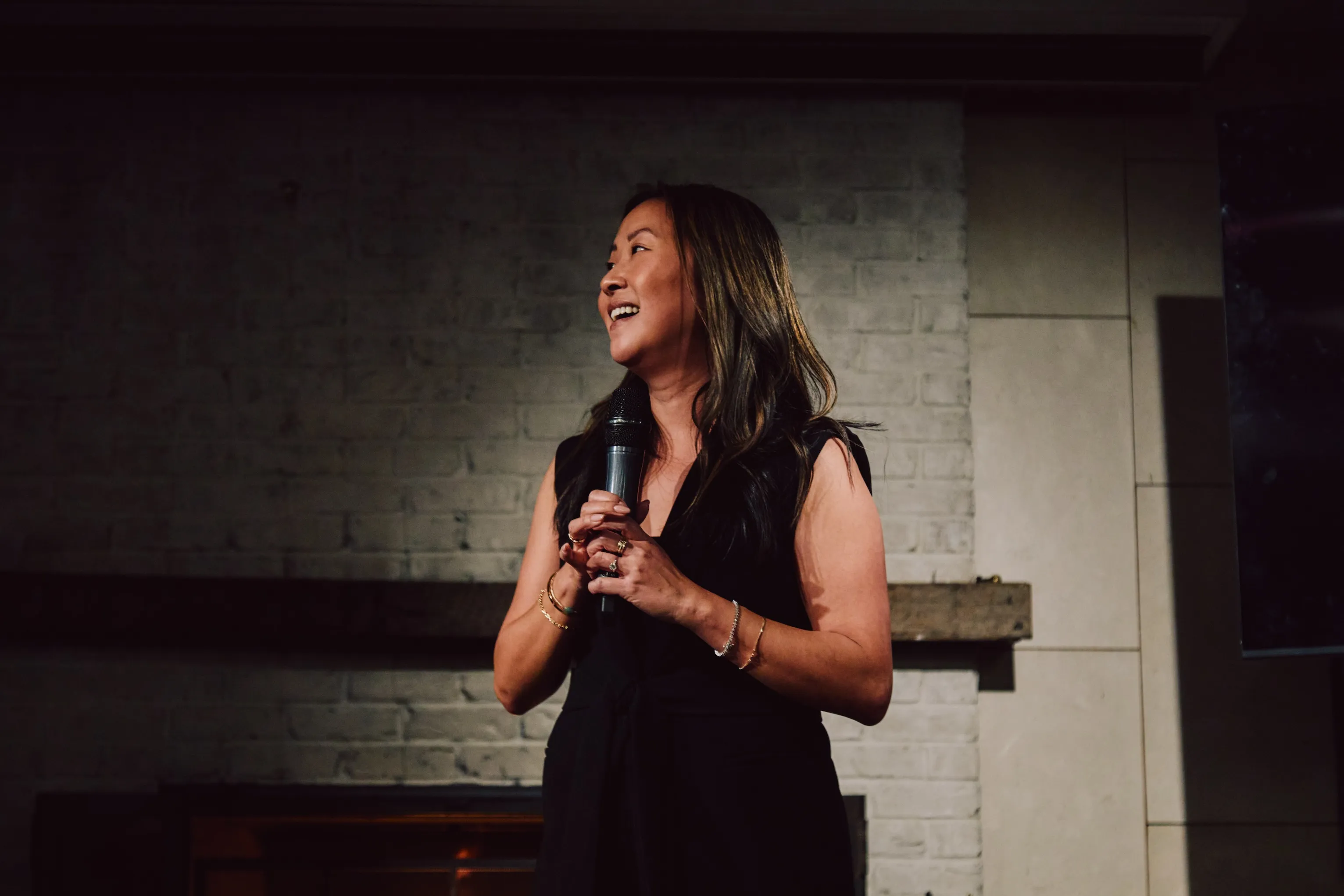 Woman speaking into a microphone during a presentation at an ehouse event.