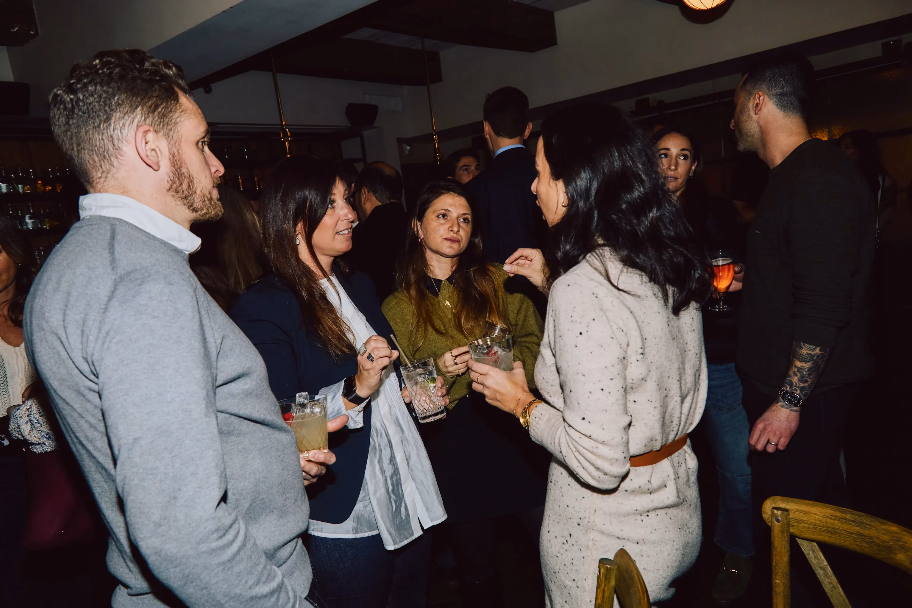 Colleagues gathered in conversation with drinks at an ehouse team party.