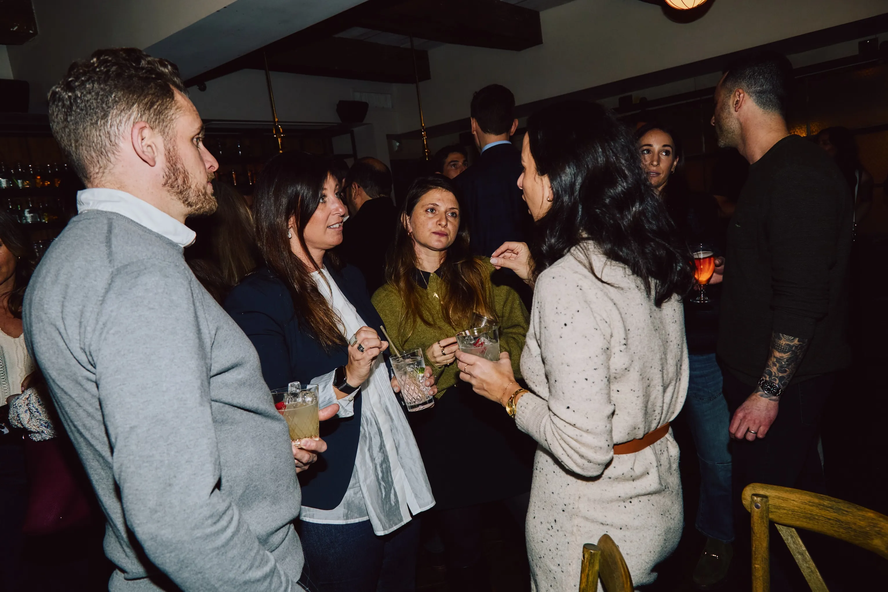 Colleagues gathered in conversation with drinks at an ehouse team party.