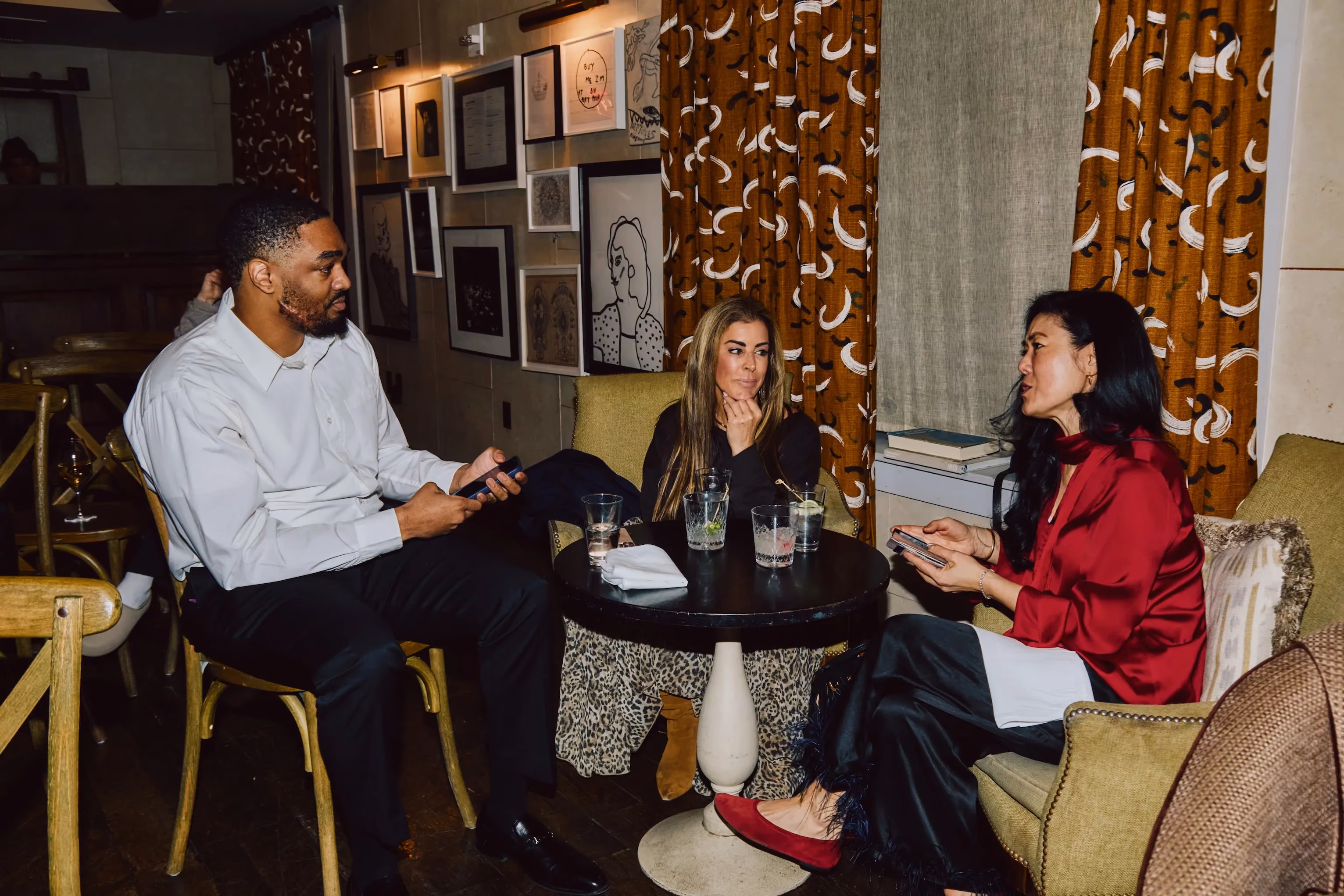 Three attendees in conversation around a small table at an ehouse networking event.