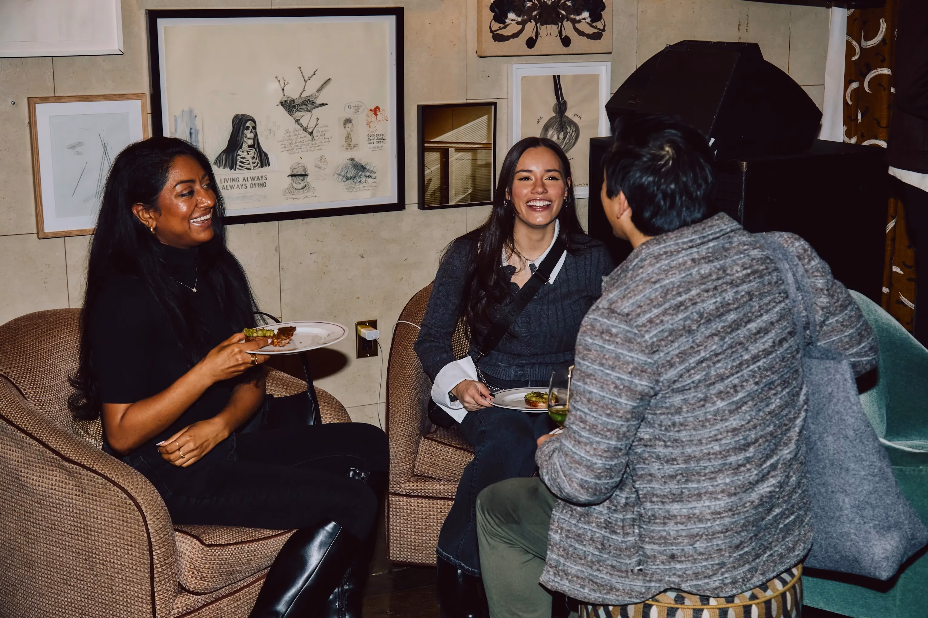 Three attendees laughing together while seated at an ehouse networking event.