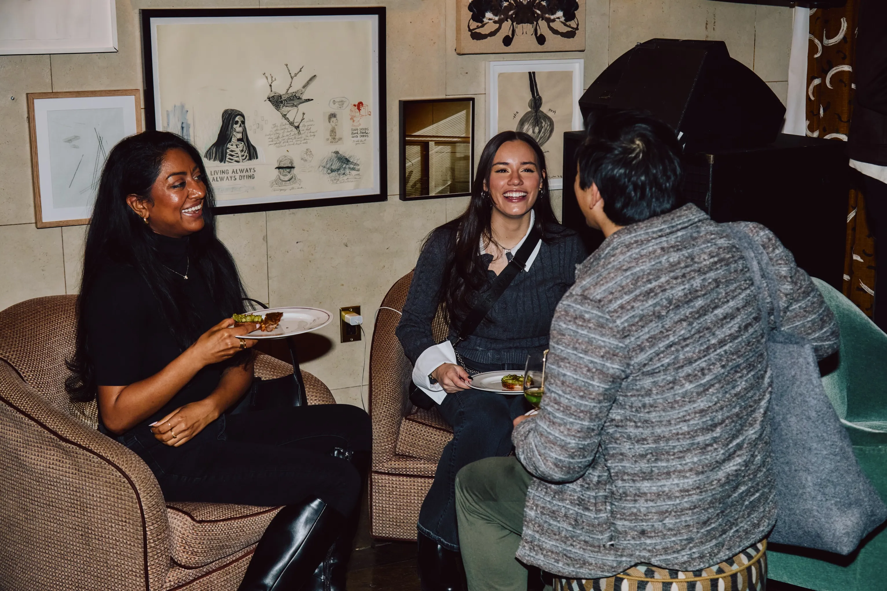 Three attendees laughing together while seated at an ehouse networking event.