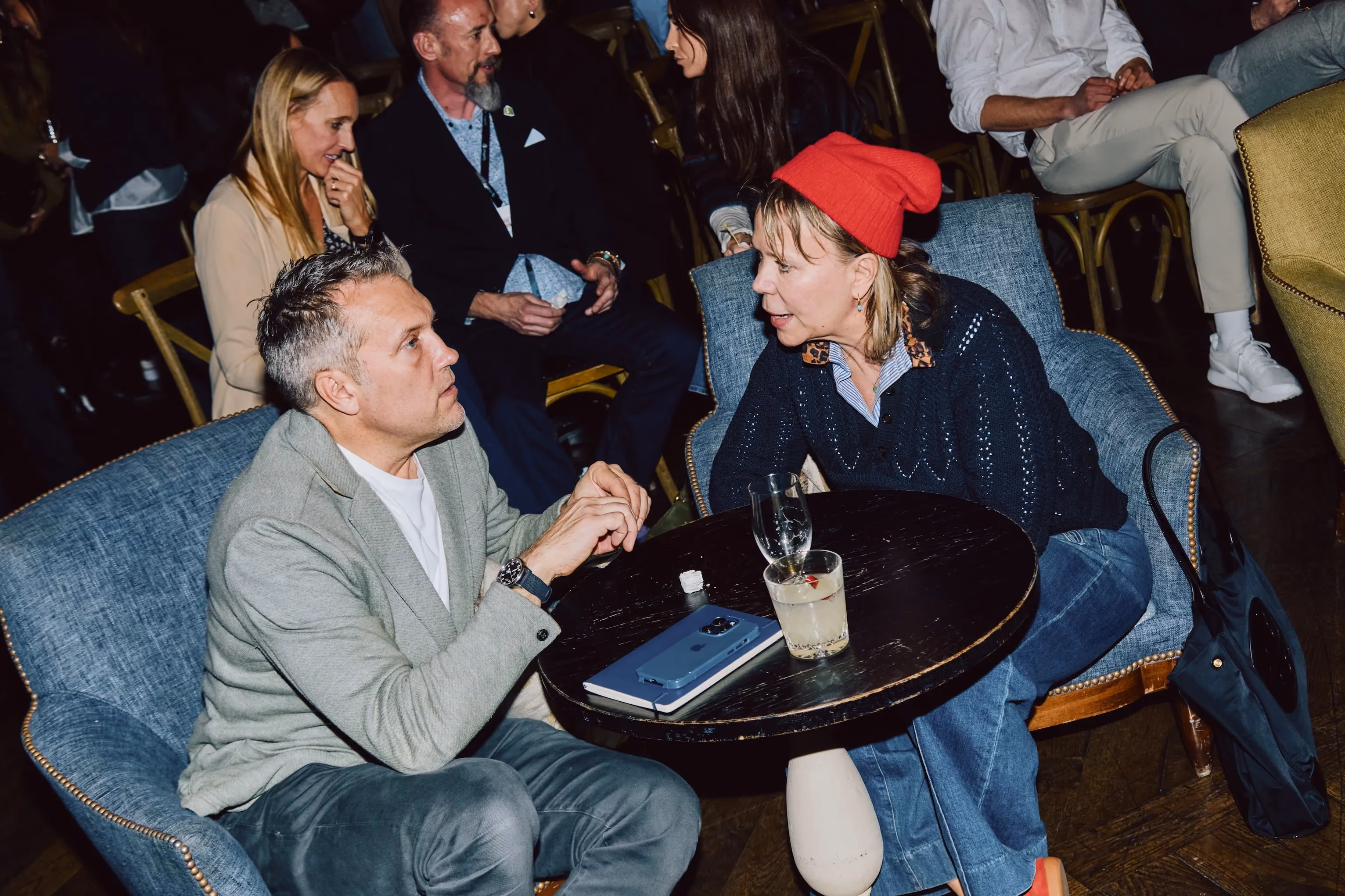 Two colleagues in conversation at a table during an ehouse team event.