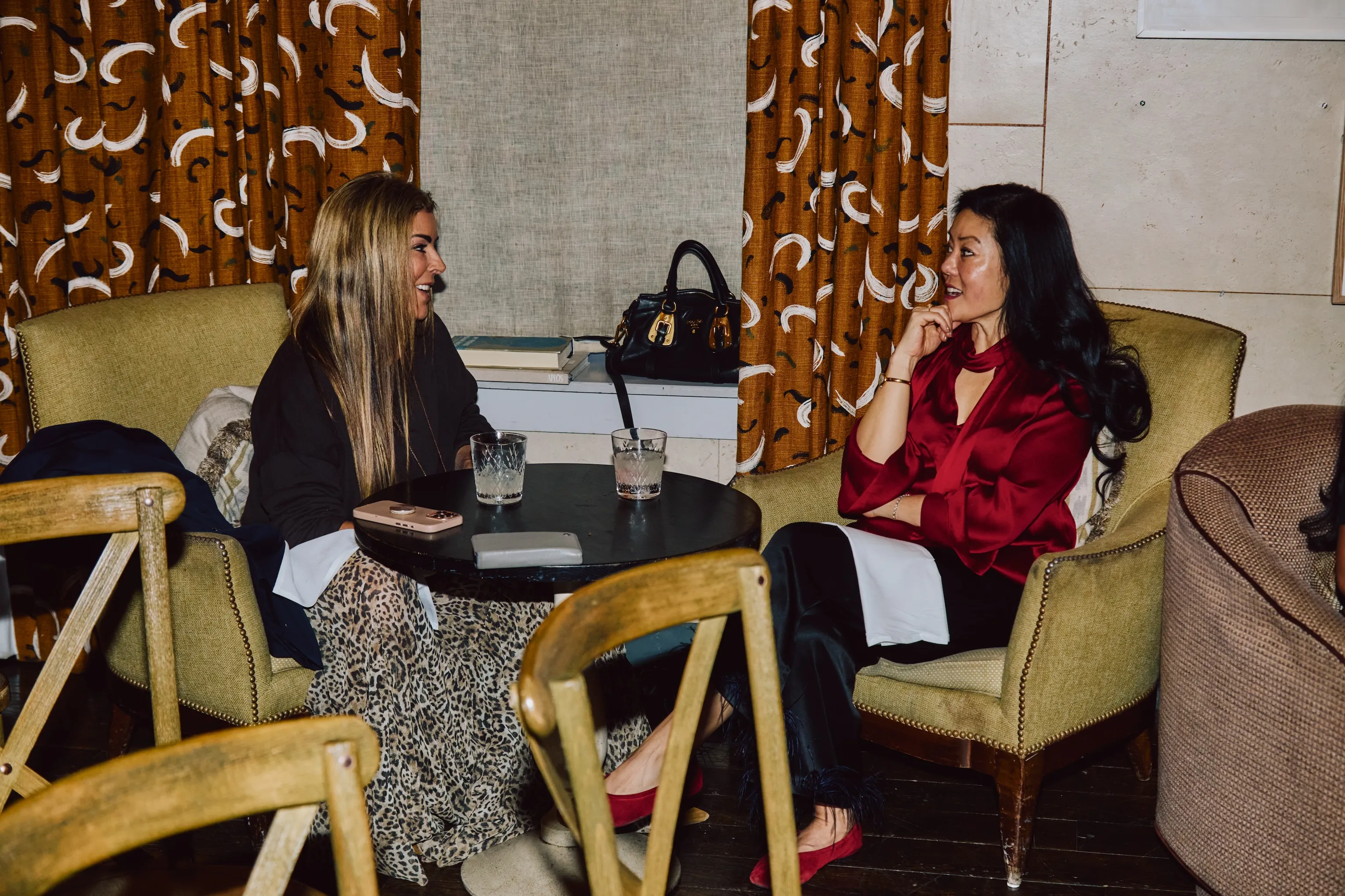 Two colleagues seated and chatting at a table during an ehouse team event.