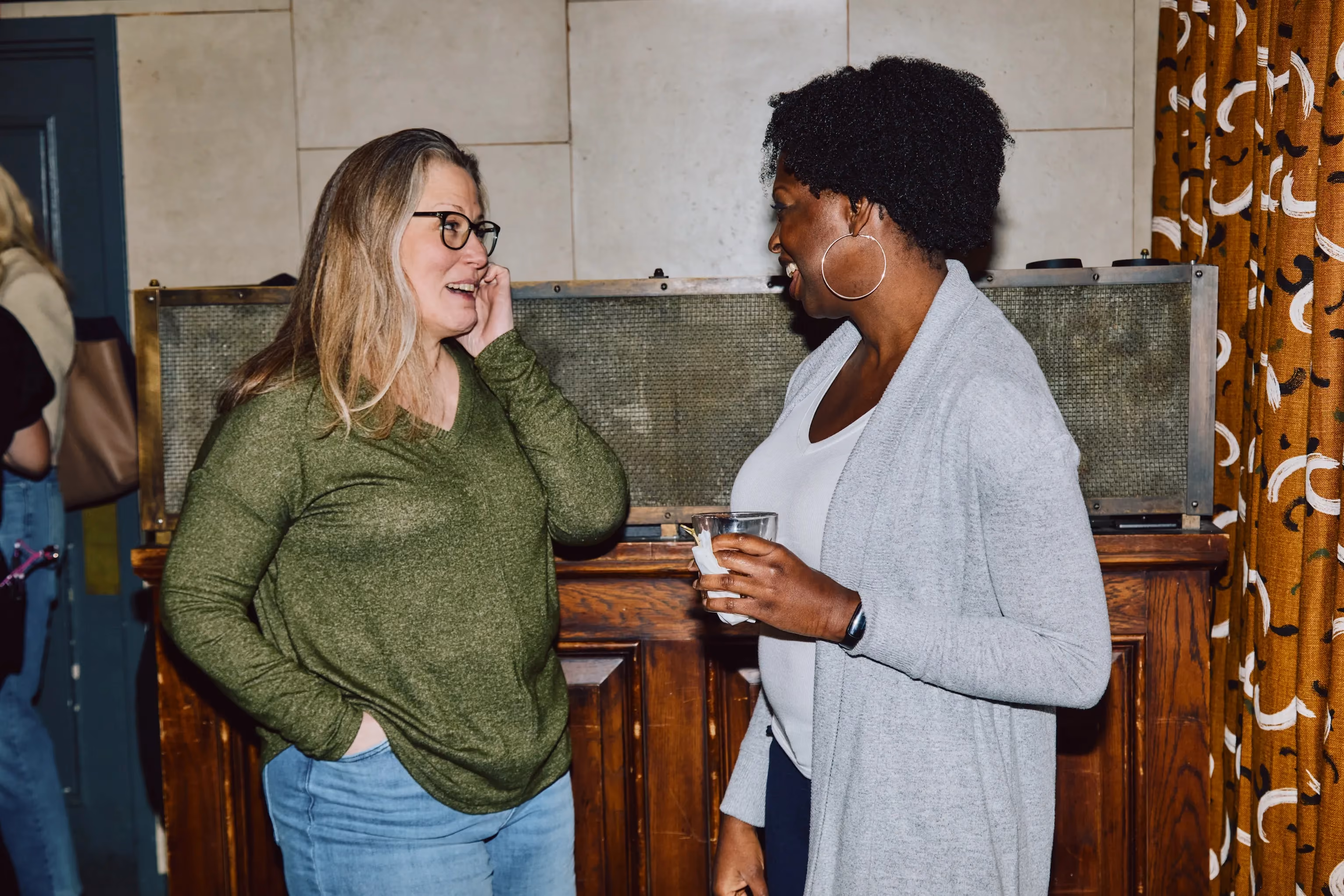 Two colleagues laughing together during an ehouse team social event.
