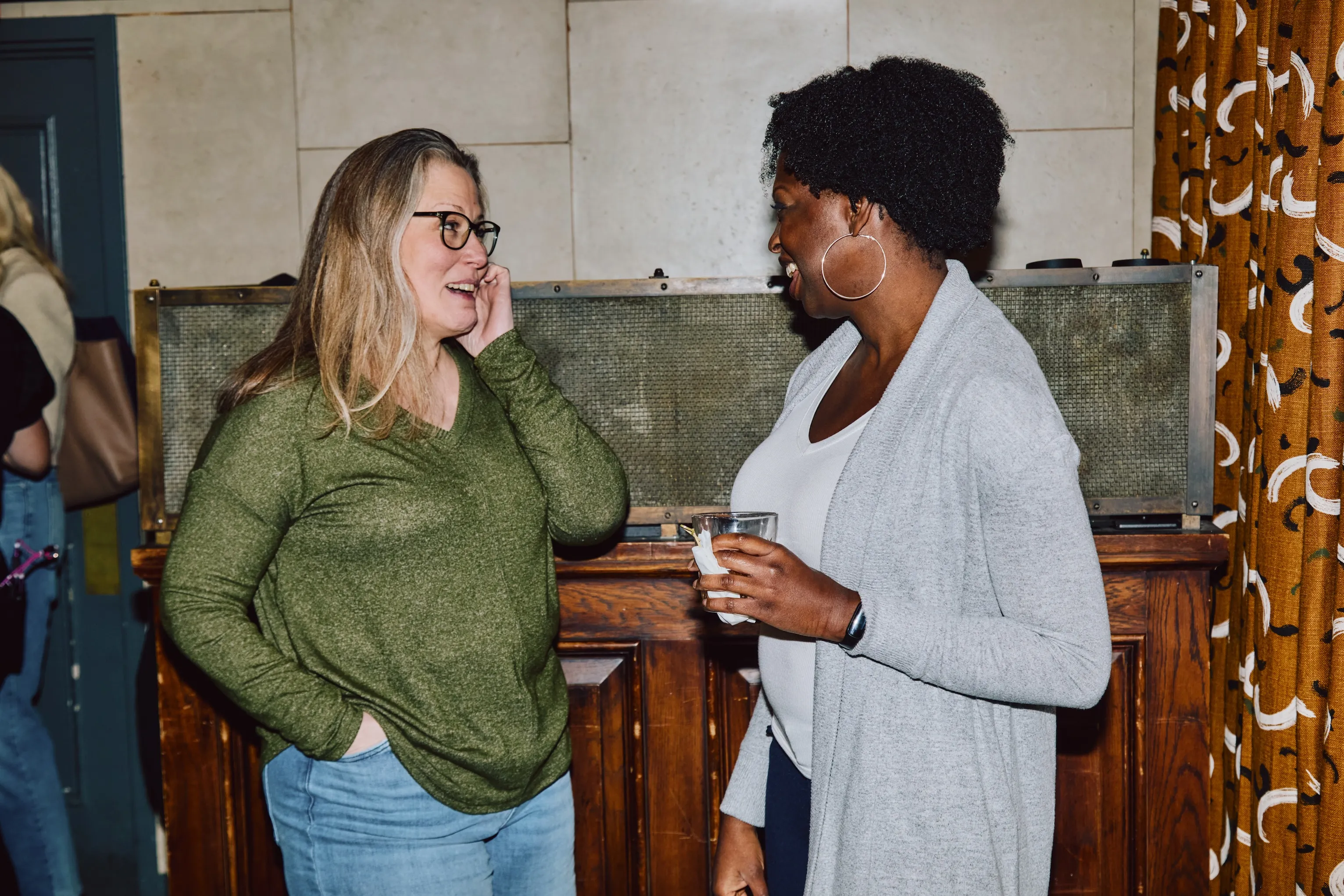 Two colleagues laughing together during an ehouse team social event.