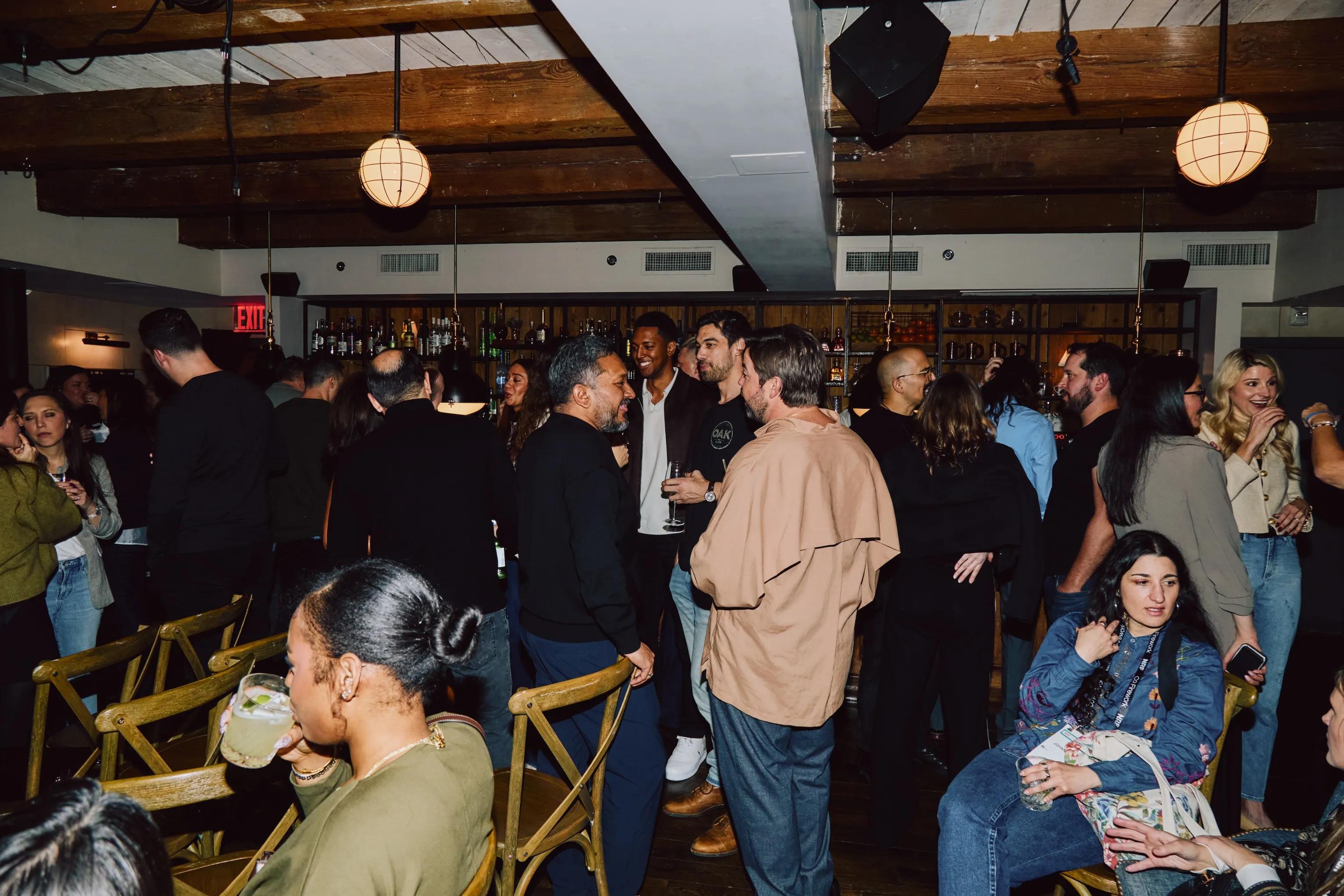 Crowd of colleagues mingling and talking at an ehouse team party.