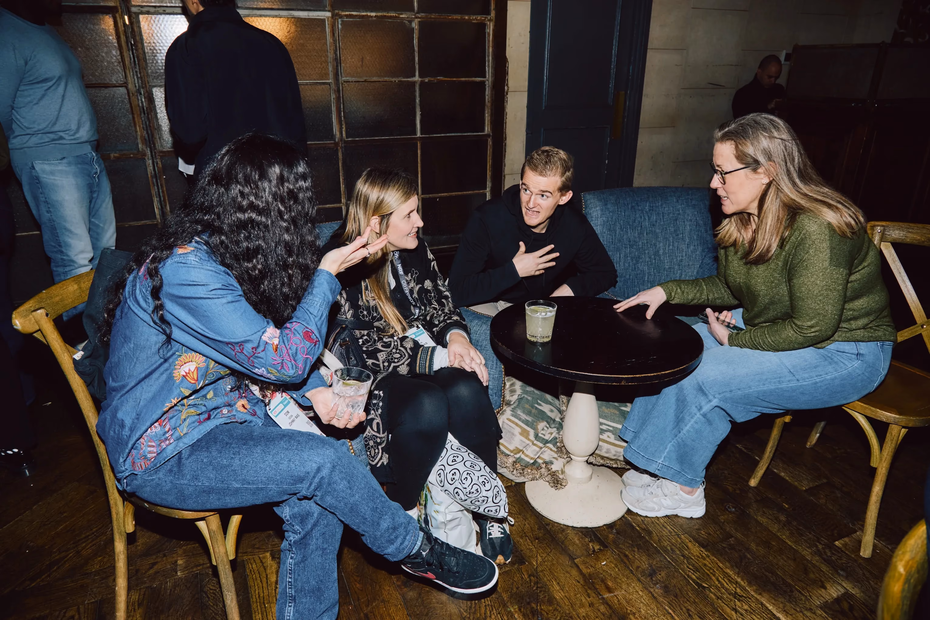 Colleagues seated around a table in conversation at an ehouse team gathering.