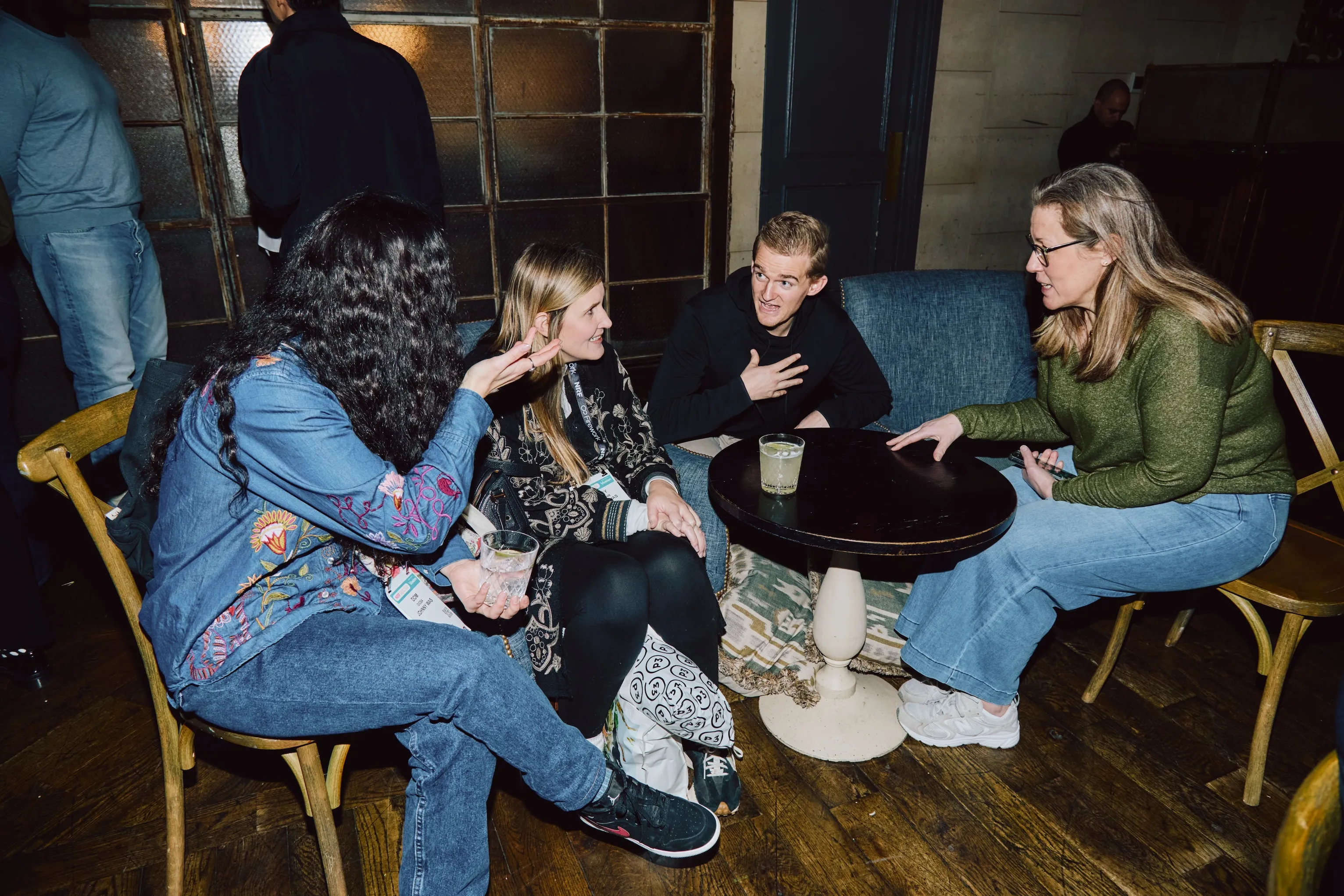 Colleagues seated around a table in conversation at an ehouse team gathering.