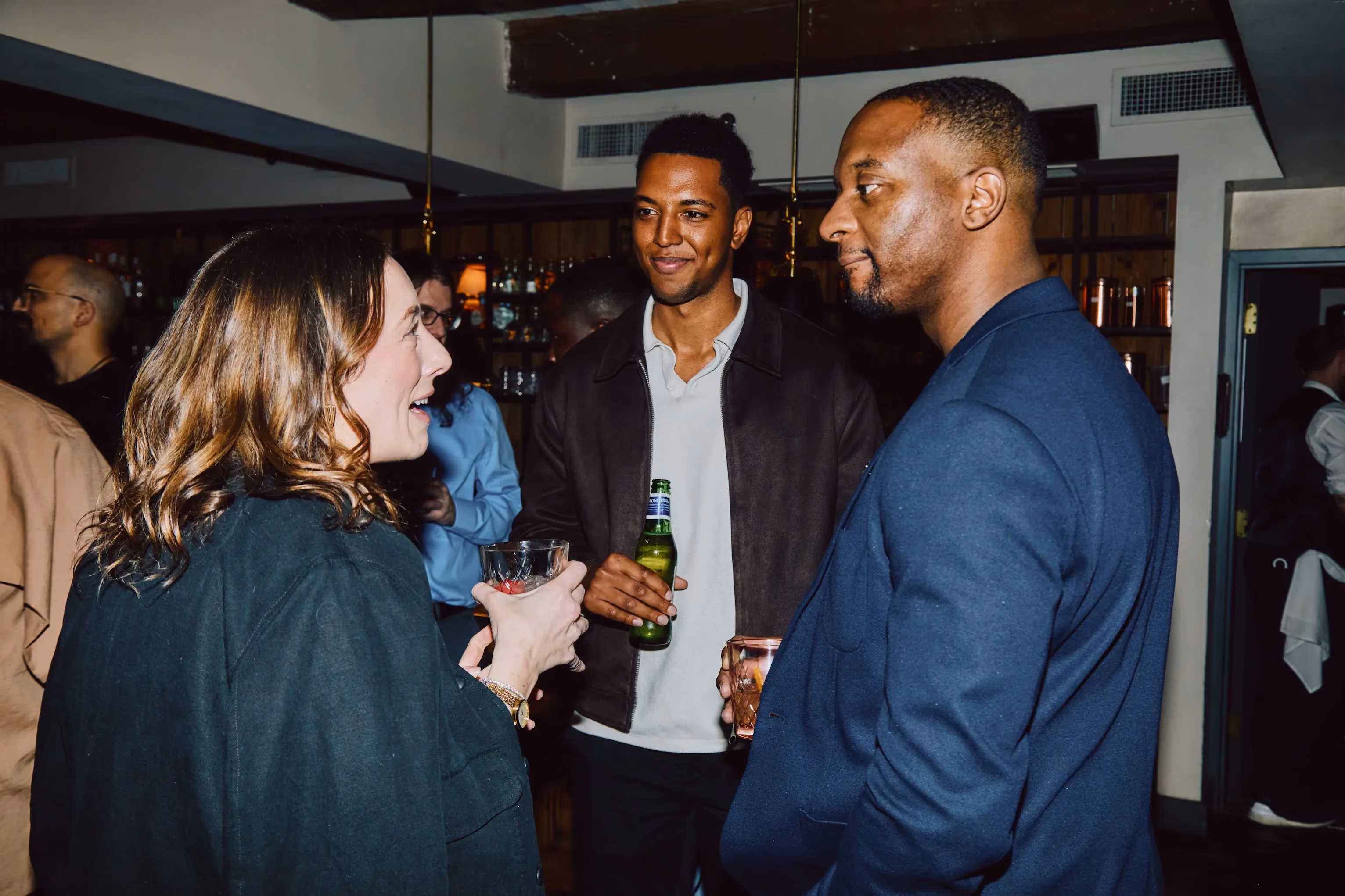Team members chatting and laughing together at an ehouse social event.