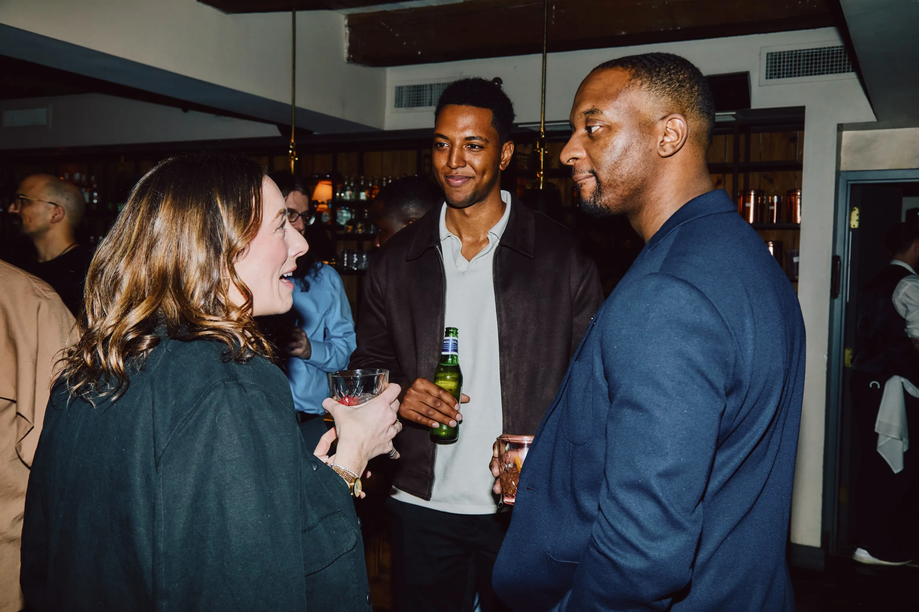 Team members chatting and laughing together at an ehouse social event.