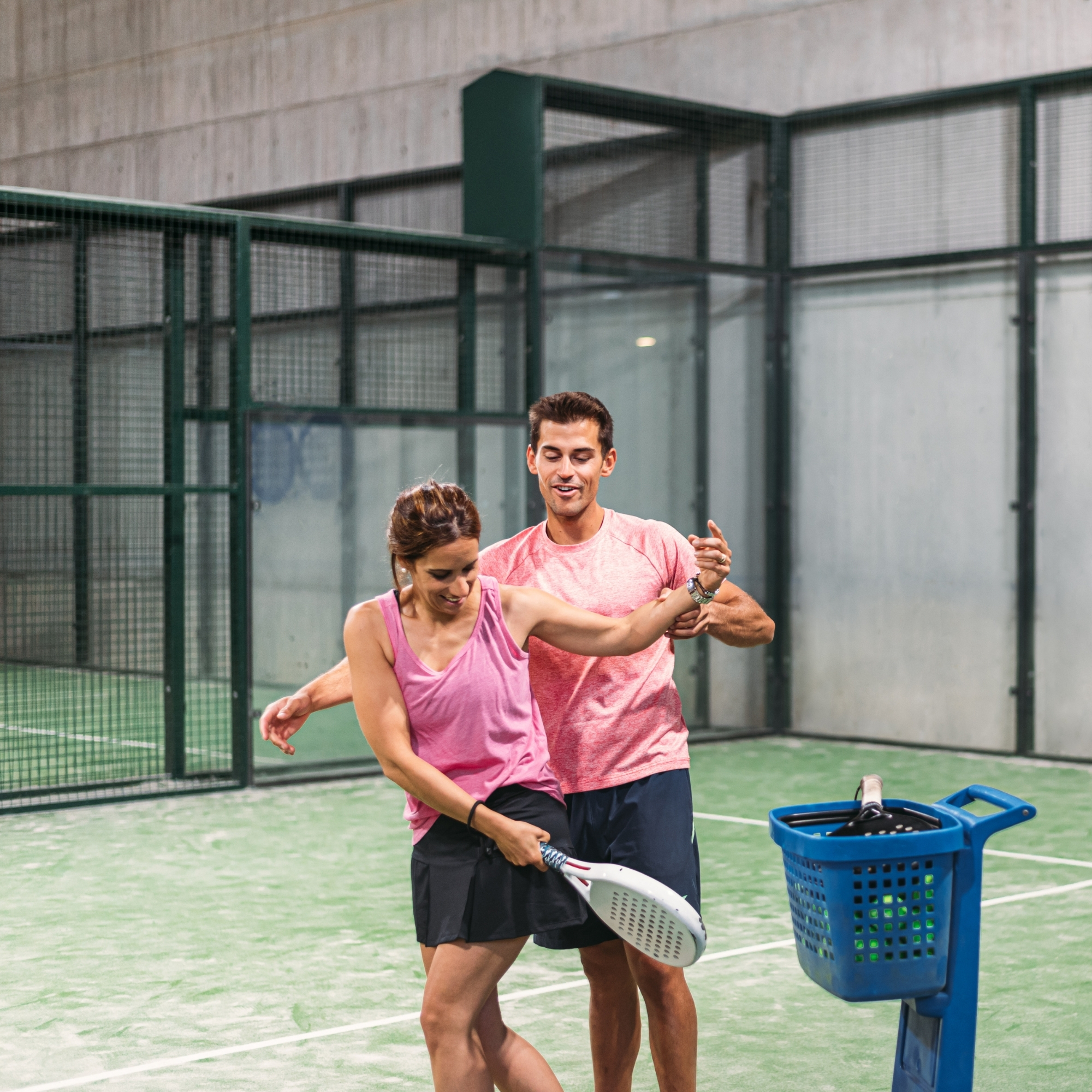 cours padle entre un professeur et son élève sur un terrain de padle d'un hotel