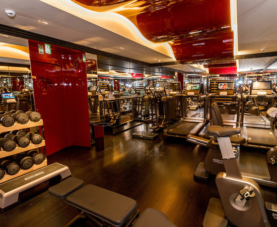 Salle de fitness de l'hôtel de luxe parisien La Réserve Paris avec beau décor rouge autour des machines de musculation