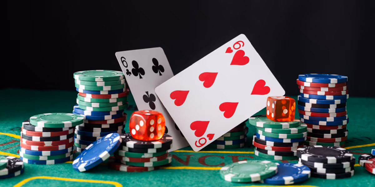 Two playing cards, six of hearts and six of clubs, surrounded by stacks of colorful poker chips and two red dice on a green casino table.
