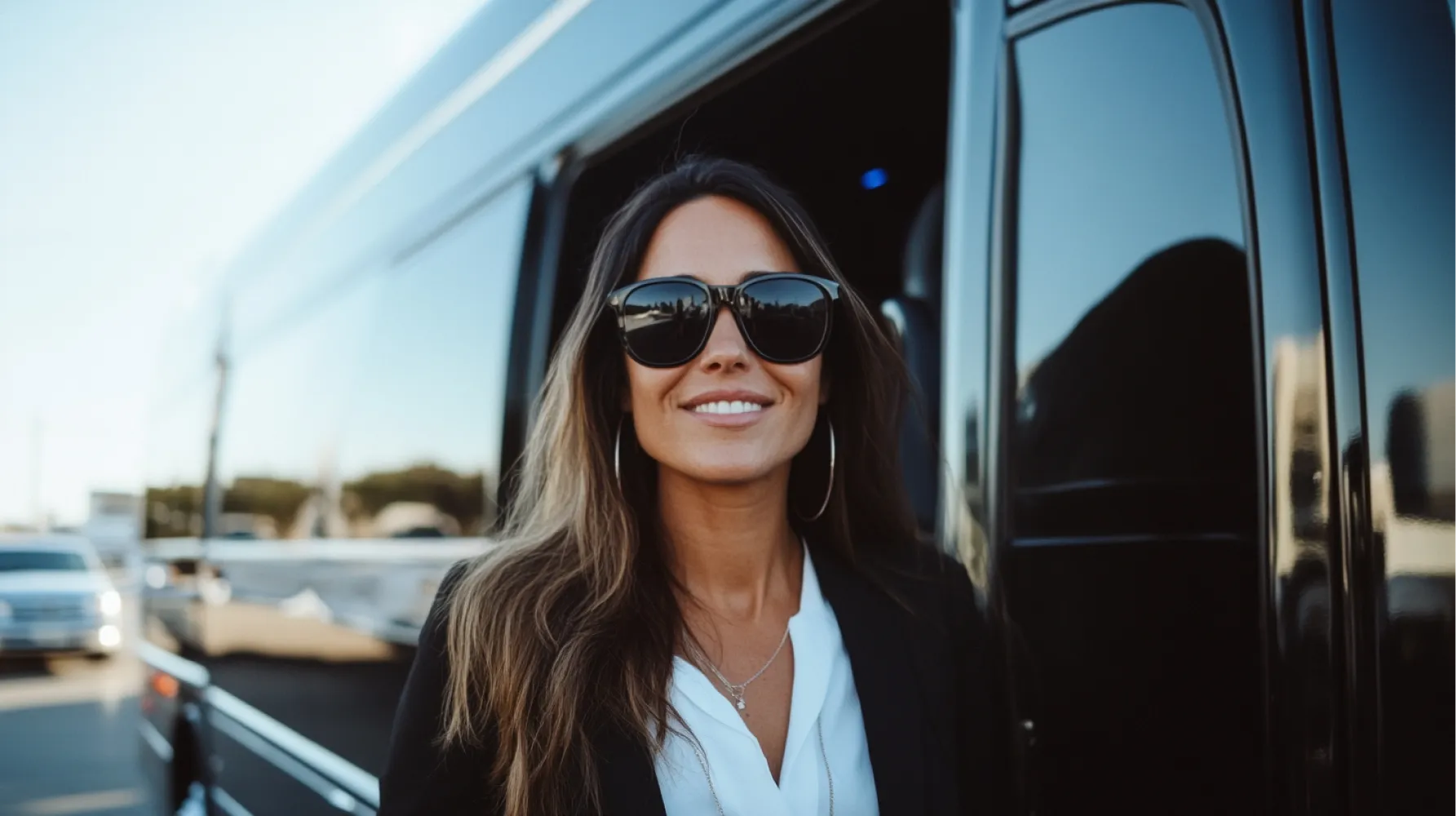 A woman wearing sunglasses and a white shirt.