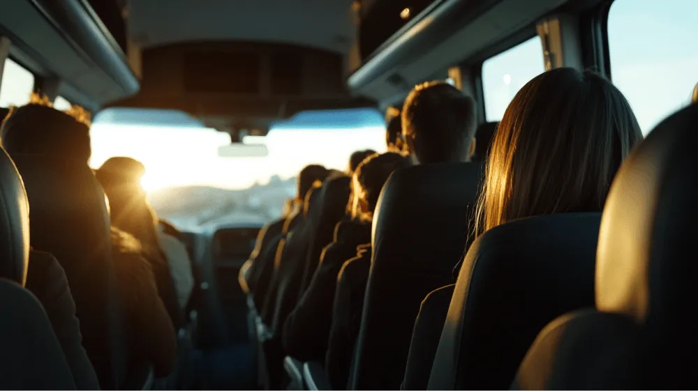 A woman with long hair is sitting in a bus seat.