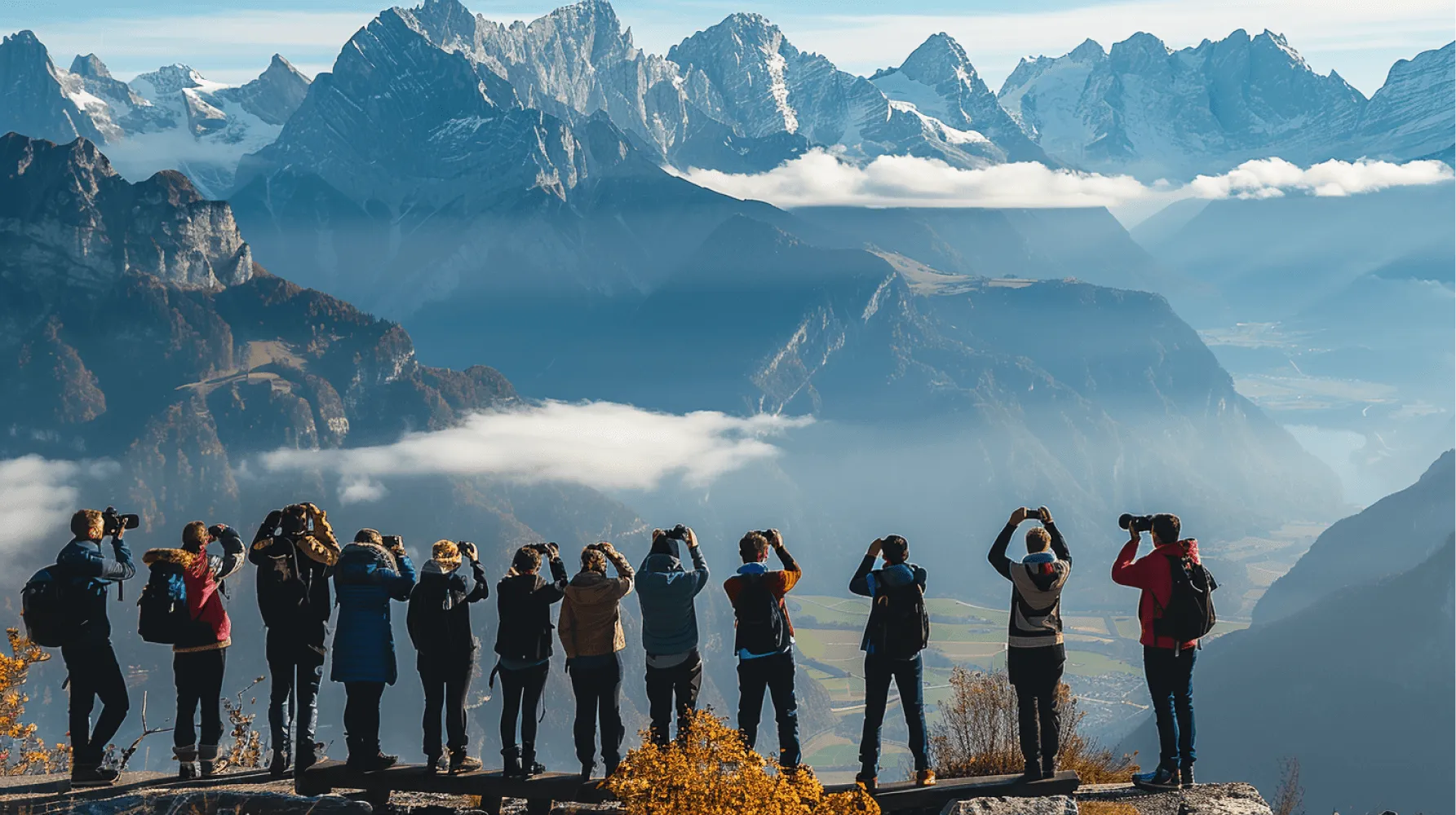 A group of people standing on a mountain top taking pictures.