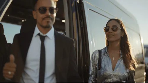 A man and woman are standing in front of a van.