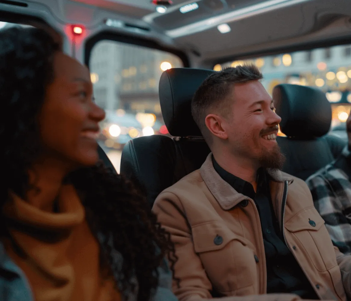 A man and woman are sitting in a vehicle, smiling and enjoying their time together.