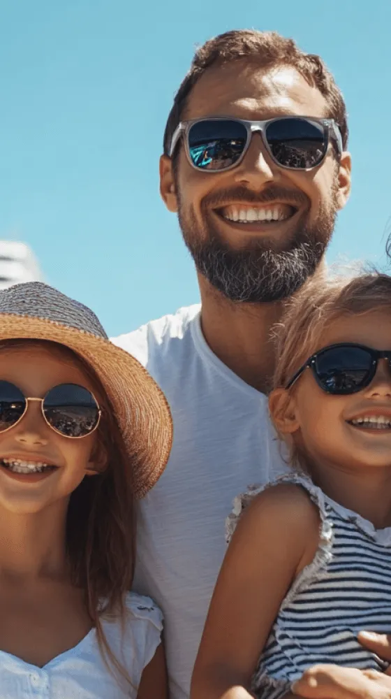 A man and two children wearing sunglasses and hats.