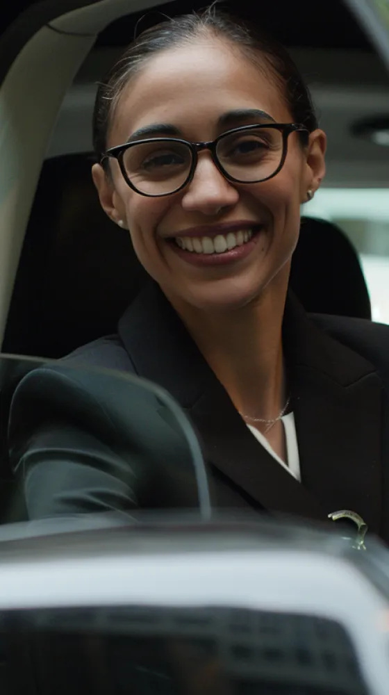 A woman wearing glasses and a black suit smiling.