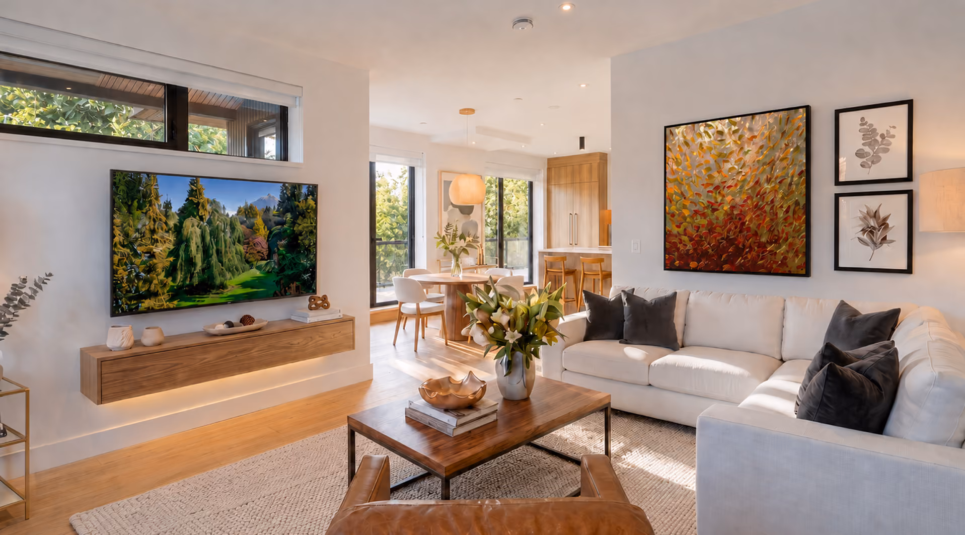 Modern living room with white sectional, brown chair, wood coffee table, and wall-mounted TV showing fireplace.