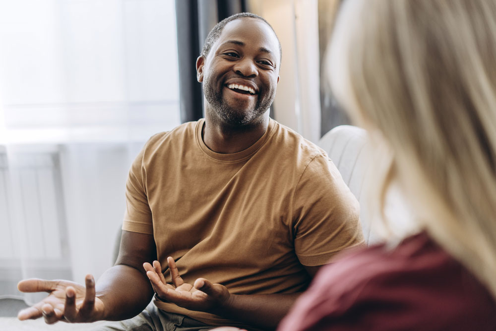 happy man smiling while talking to his therapist in Lethbridge